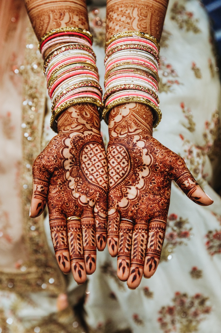 Indian wedding mehndi — intricate henna and colourful bangles on the bride's hands